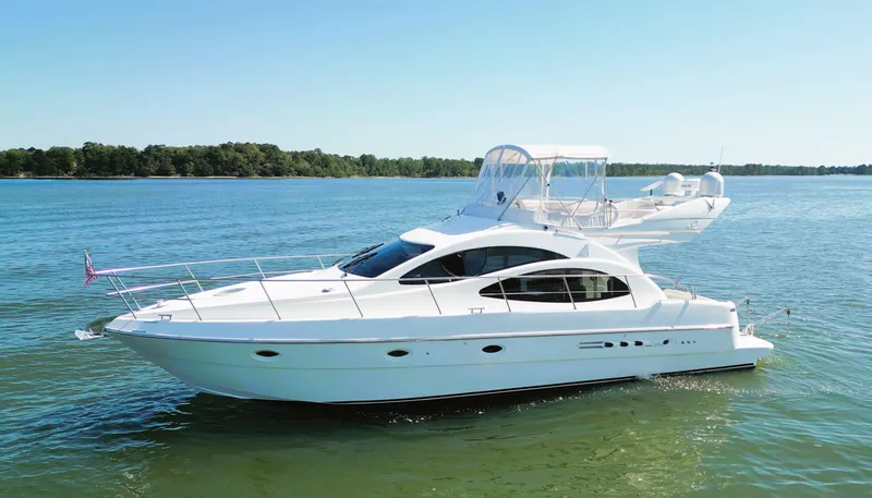 Slide: The Image of 2002 Azimut 42 yacht cruising on a serene lake under clear blue skies. - 3