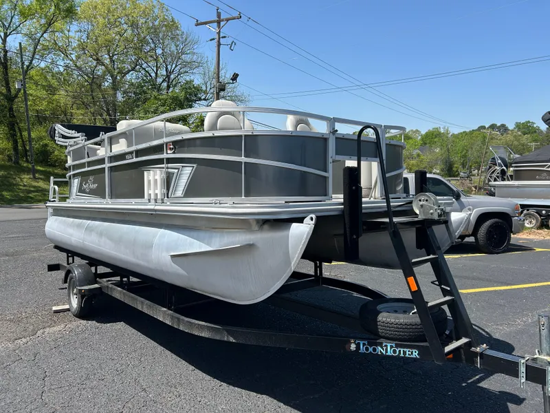 Slide: The Image of 2020 SunChaser Vista 18 Fish pontoon boat on trailer in parking lot. - 1