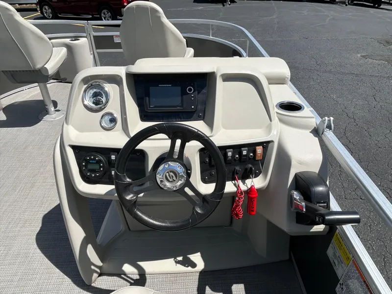 Slide: The Image of 2020 SunChaser Vista 18 Fish boat dashboard with steering wheel and control panel. - 9