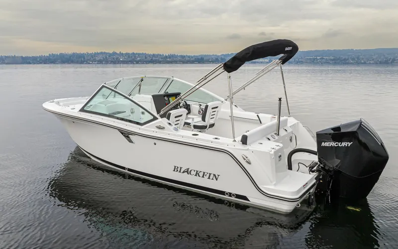 Slide: The Image of 2024 Blackfin 232DC Dual Console boat on calm water with Mercury outboard engine. - 1
