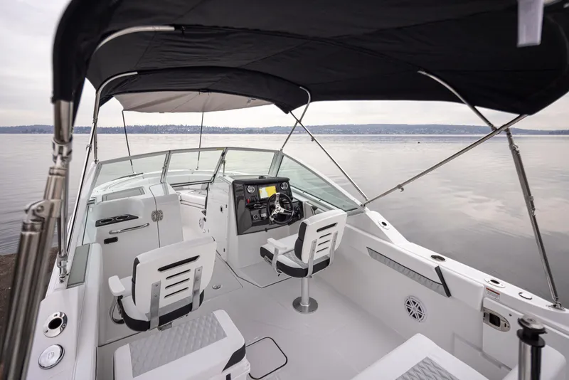 Slide: The Image of 2024 Blackfin 232DC Dual Console boat interior with seating and helm, on calm water. - 34