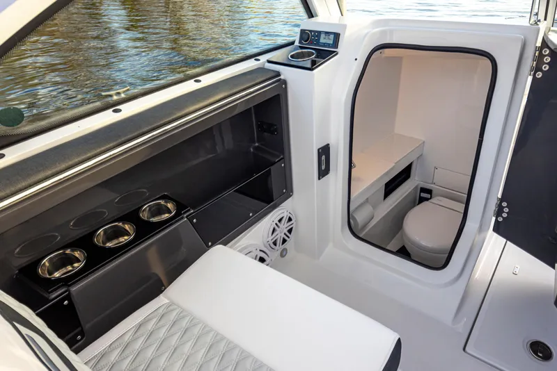 Slide: The Image of 2024 Blackfin 252 DC boat interior with seating, cup holders, and compact restroom. - 25