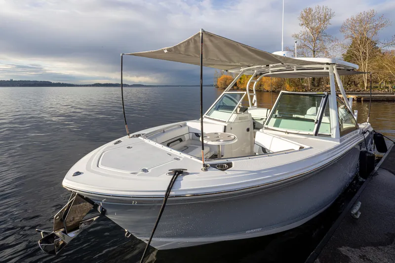 Slide: The Image of 2024 Blackfin 252 DC boat docked on a serene lake with canopy. - 35