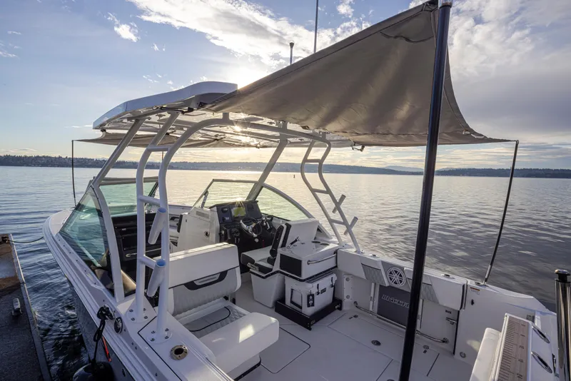 Slide: The Image of 2024 Blackfin 252 DC boat with canopy on calm water at sunset. - 37