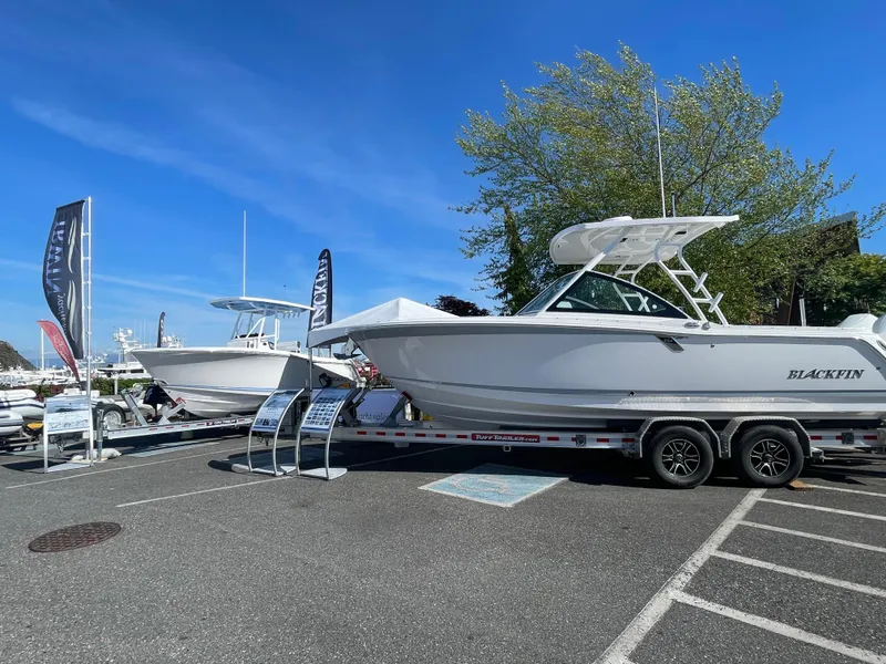 Slide: The Image of 2024 Blackfin 252 DC boat displayed on a trailer in a parking lot. - 40