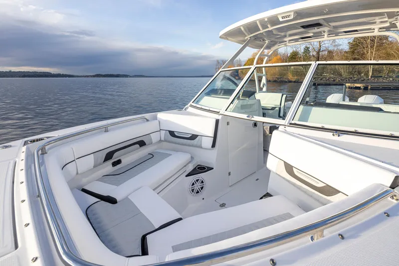 Slide: The Image of 2024 Blackfin 252 DC boat interior with white seating, on a calm lake. - 9