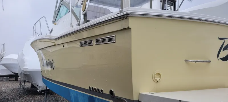 Slide: The Image of 2006 Wellcraft 330 Coastal boat, yellow hull, docked in a marina. - 11
