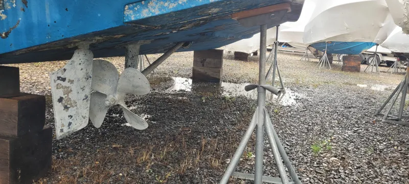 Slide: The Image of 2006 Wellcraft 330 Coastal boat on stands, showing propellers and hull in a storage yard. - 17