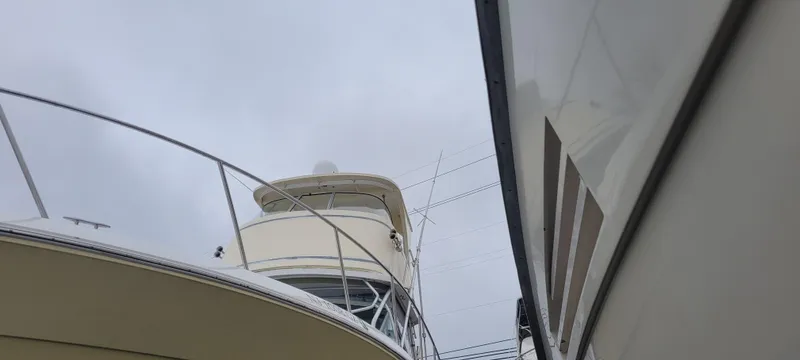 Slide: The Image of 2006 Wellcraft 330 Coastal boat docked, viewed from below against a cloudy sky. - 18