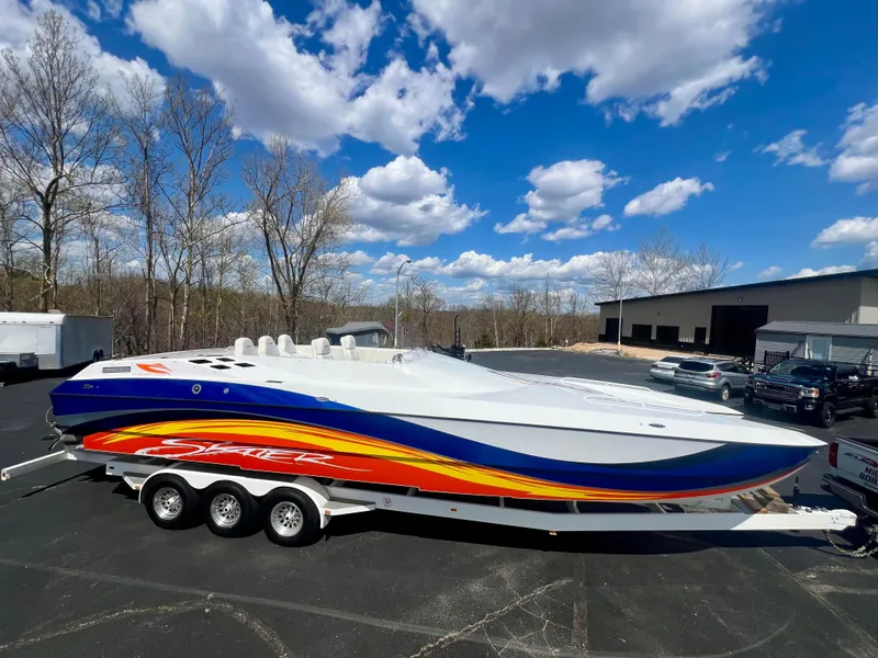 Slide: The Image of 2001 Skater 32B speedboat with vibrant graphics on a trailer under a blue sky. - 1