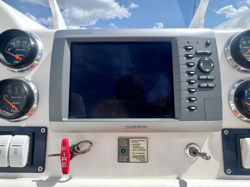 Slide: The Image of Boat dashboard with Garmin GPS, gauges, and controls under a clear sky. Skater 32B, 2001 model. - 10
