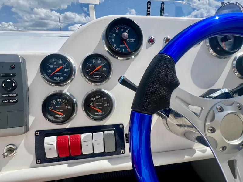 Slide: The Image of Dashboard of a 2001 Skater 32B boat with gauges and blue steering wheel. - 12