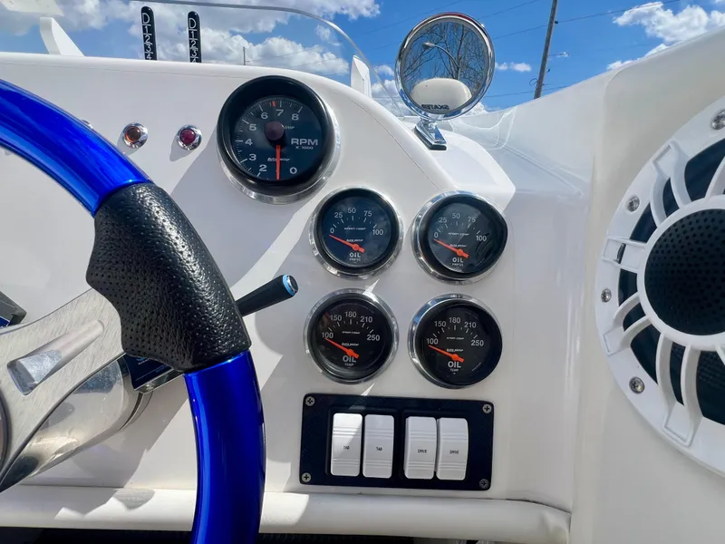 Slide: The Image of Dashboard of a 2001 Skater 32B boat with gauges and blue steering wheel. - 13