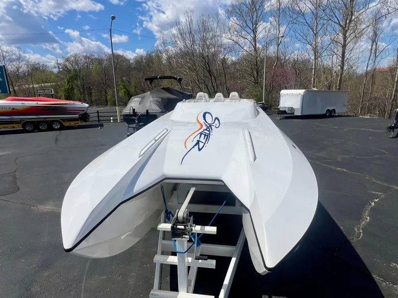 Slide: The Image of White Skater 32B powerboat on trailer, parked outdoors under a blue sky. - 18