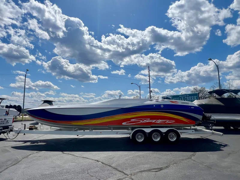 Slide: The Image of 2001 Skater 32B powerboat on trailer under a bright blue sky with clouds. - 2
