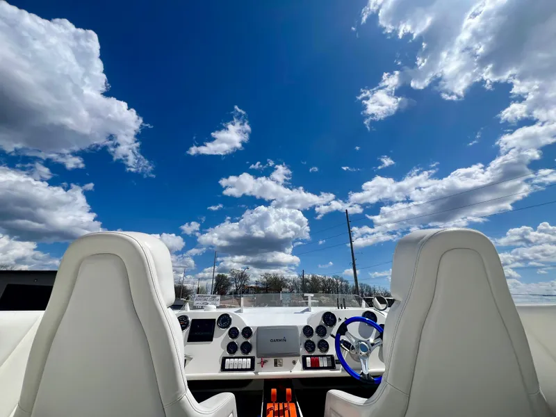 Slide: The Image of Cockpit view of a 2001 Skater 32B boat under a vibrant blue sky with clouds. - 21
