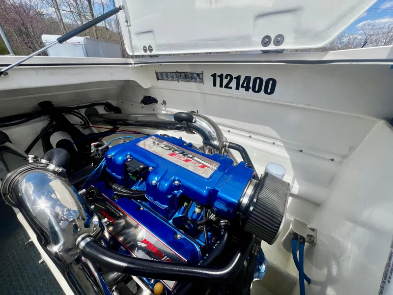 Slide: The Image of Engine compartment of a 2001 Skater 32B boat, featuring a blue high-performance engine. - 23