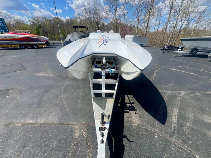 Slide: The Image of Front view of a 2001 Skater 32B boat on a trailer in a parking lot. - 30