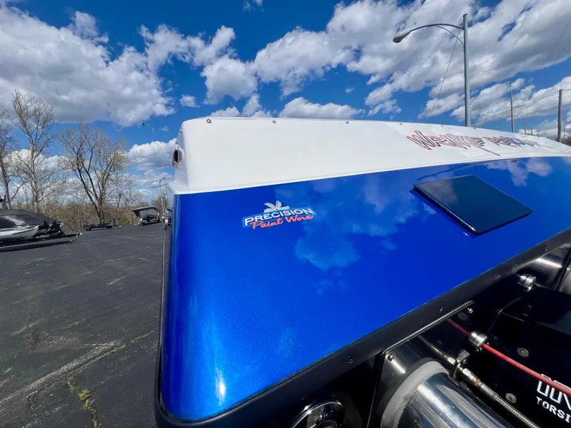 Slide: The Image of 2001 Skater 32B boat with blue and white design under a cloudy sky. - 35