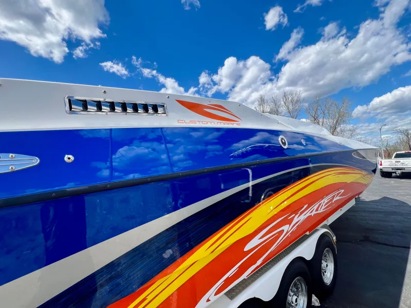 Slide: The Image of Colorful 2001 Skater 32B speedboat with vibrant graphics against a bright blue sky. - 36