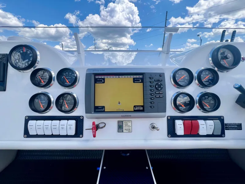 Slide: The Image of Dashboard of a 2001 Skater 32B boat with gauges and navigation system under a blue sky. - 9