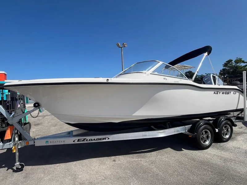Slide: The Image of 2022 Key West 239 DFS boat on trailer under clear blue sky. - 2