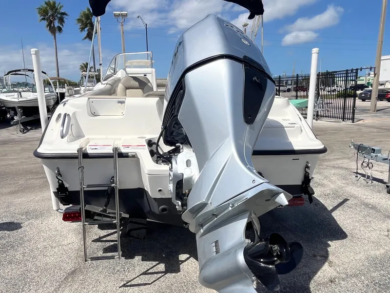 Slide: The Image of 2022 Key West 239 DFS boat with powerful outboard motor, parked outdoors under blue sky. - 4