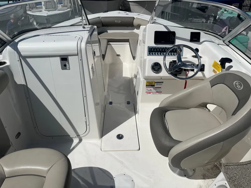 Slide: The Image of 2022 Key West 239 DFS boat interior with steering wheel and seating area. - 8