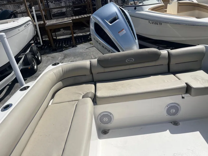 Slide: The Image of 2022 Key West 239 DFS boat interior with beige seating and visible outboard motor. - 9
