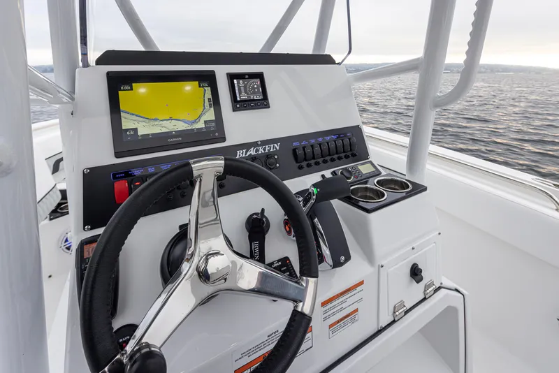 Slide: The Image of 2024 Blackfin 222 CC boat dashboard with navigation display and steering wheel. - 10