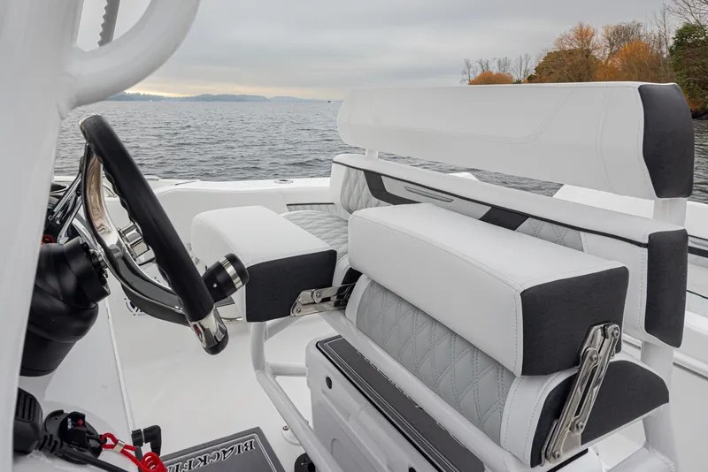 Slide: The Image of 2024 Blackfin 222 CC boat interior with sleek white seating and steering wheel. - 13