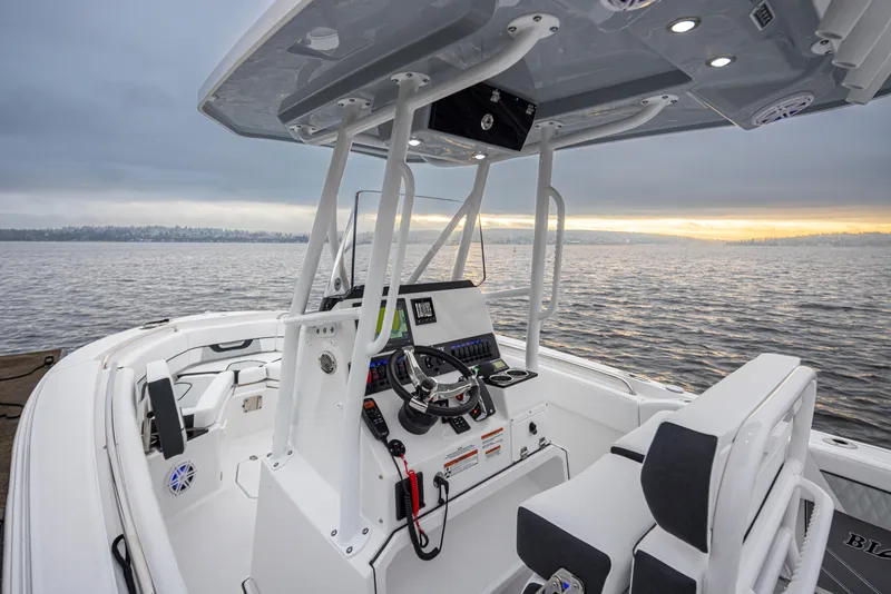 Slide: The Image of 2024 Blackfin 222 CC boat interior with modern console, on a calm lake at sunset. - 15