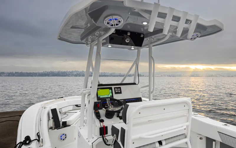 Slide: The Image of 2024 Blackfin 222 CC boat interior with helm, overlooking serene water at sunset. - 16