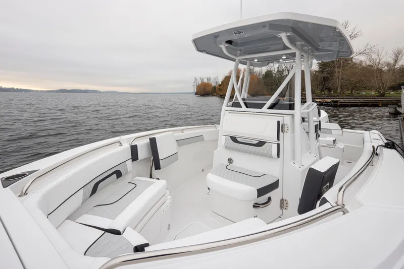 Slide: The Image of 2024 Blackfin 222 CC boat interior with seating, on a calm lake. - 18