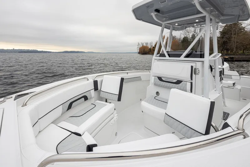 Slide: The Image of 2024 Blackfin 222 CC boat interior with white seating, on a calm lake. - 22