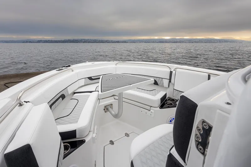 Slide: The Image of 2024 Blackfin 222 CC boat interior with seating and table, overlooking a serene water view. - 24