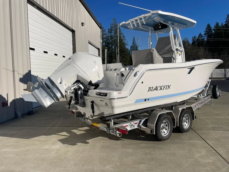 Slide: The Image of 2024 Blackfin 222 CC boat on trailer, parked outside a warehouse. - 3