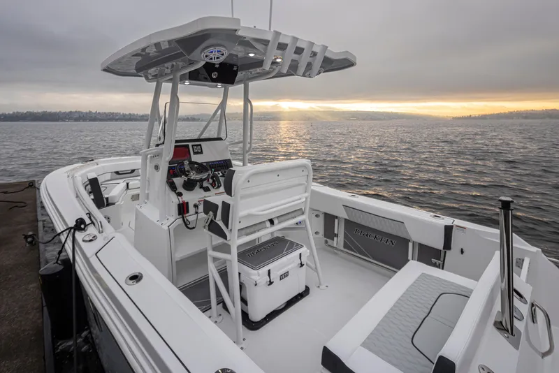 Slide: The Image of 2024 Blackfin 222 CC boat interior with helm, seating, and ocean view at sunset. - 9