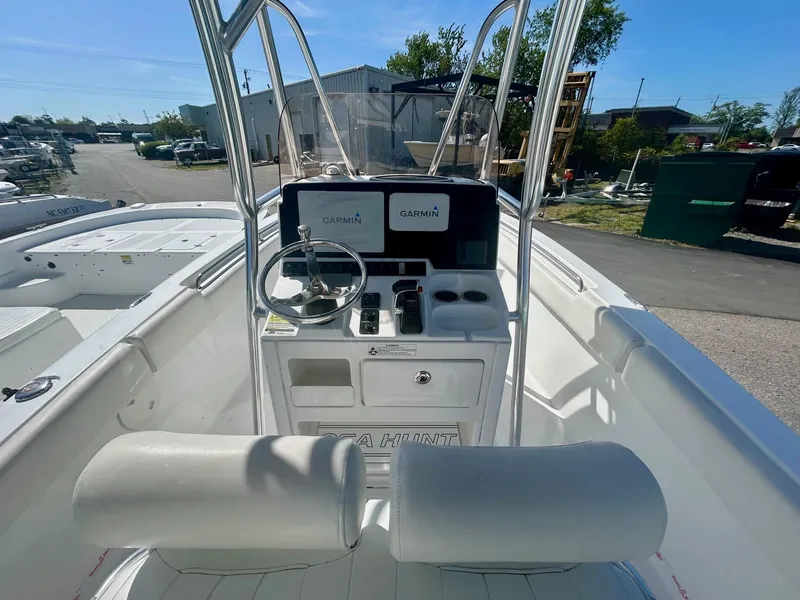 Slide: The Image of 2018 Sea Hunt Triton 225 boat cockpit with steering wheel and Garmin displays. - 2