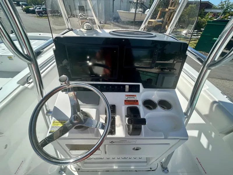 Slide: The Image of 2018 Sea Hunt Triton 225 boat console with steering wheel and navigation controls. - 3