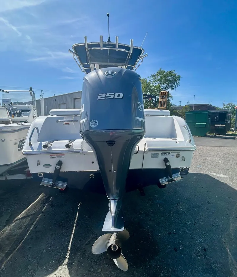Slide: The Image of 2018 Sea Hunt Triton 225 boat with powerful 250 HP engine, docked outdoors. - 4