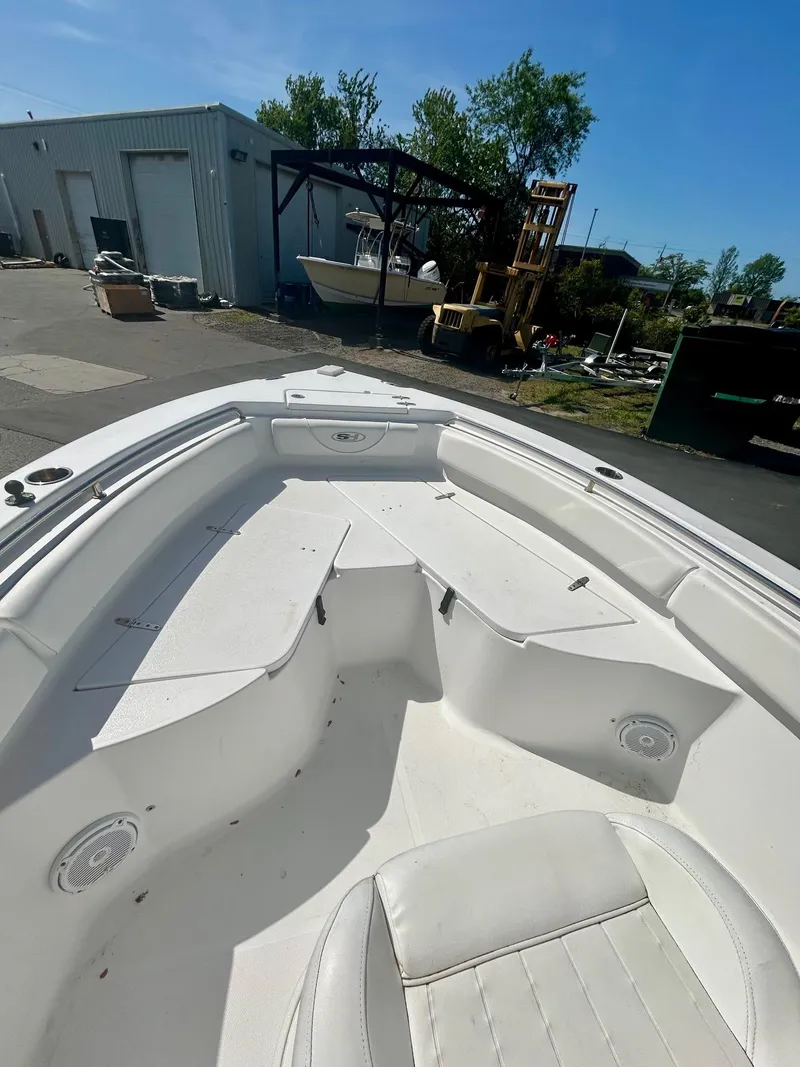 Slide: The Image of 2018 Sea Hunt Triton 225 boat interior, white seating, outdoor storage area in background. - 8