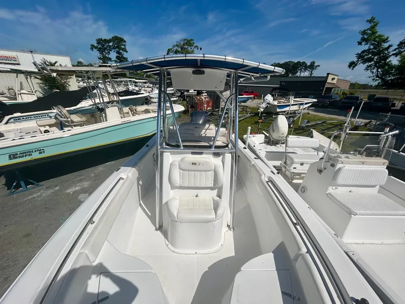 Slide: The Image of 2018 Sea Hunt Triton 225 boat with T-top, docked among other vessels under a clear blue sky. - 9