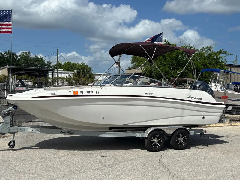 Slide: The Image of 2019 Hurricane SD217 boat on trailer, parked outdoors under a cloudy sky. - 10