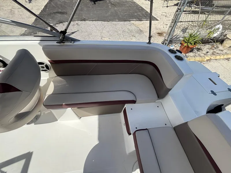 Slide: The Image of 2019 Hurricane SD217 boat interior with beige and maroon seating, cup holders, and outdoor setting. - 37