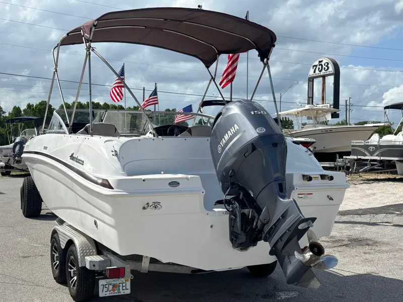 Slide: The Image of 2019 Hurricane SD217 boat with Yamaha engine, American flags, and canopy on trailer. - 4