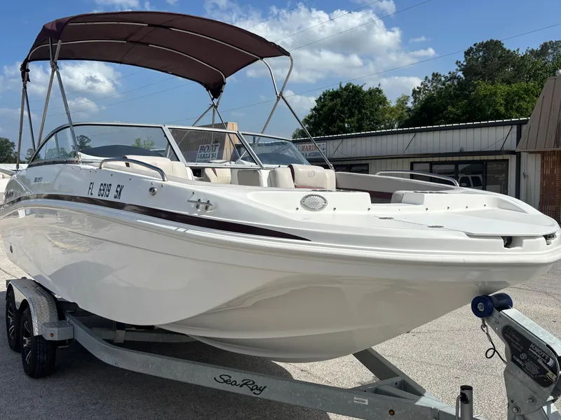 Slide: The Image of 2019 Hurricane SD217 boat on trailer with canopy, parked outdoors under blue sky. - 8