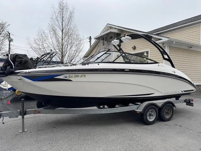 Slide: The Image of 2016 Yamaha Boats 242 Limited S on trailer, parked near a building. - 0