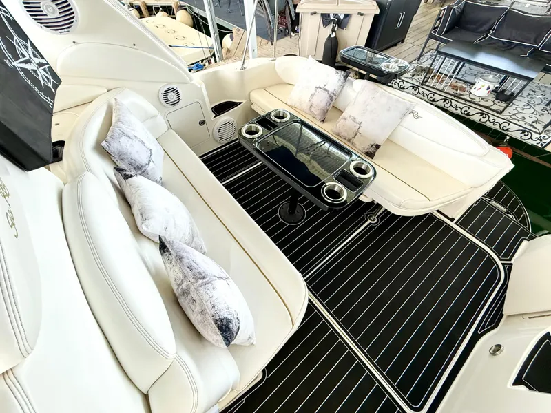 Slide: The Image of 1999 Sea Ray 340 Sundancer boat interior with white seating and decorative pillows. - 10