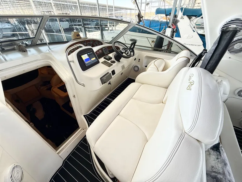 Slide: The Image of 1999 Sea Ray 340 Sundancer cockpit with white seating and modern dashboard controls. - 11